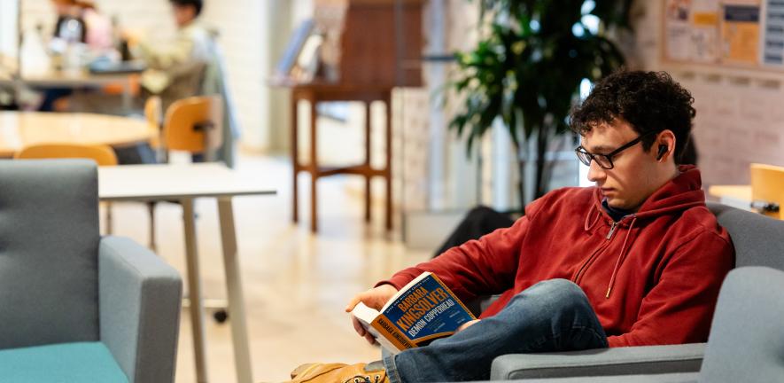 A library user reading in a comfortable armchair in the Chemistry Library.